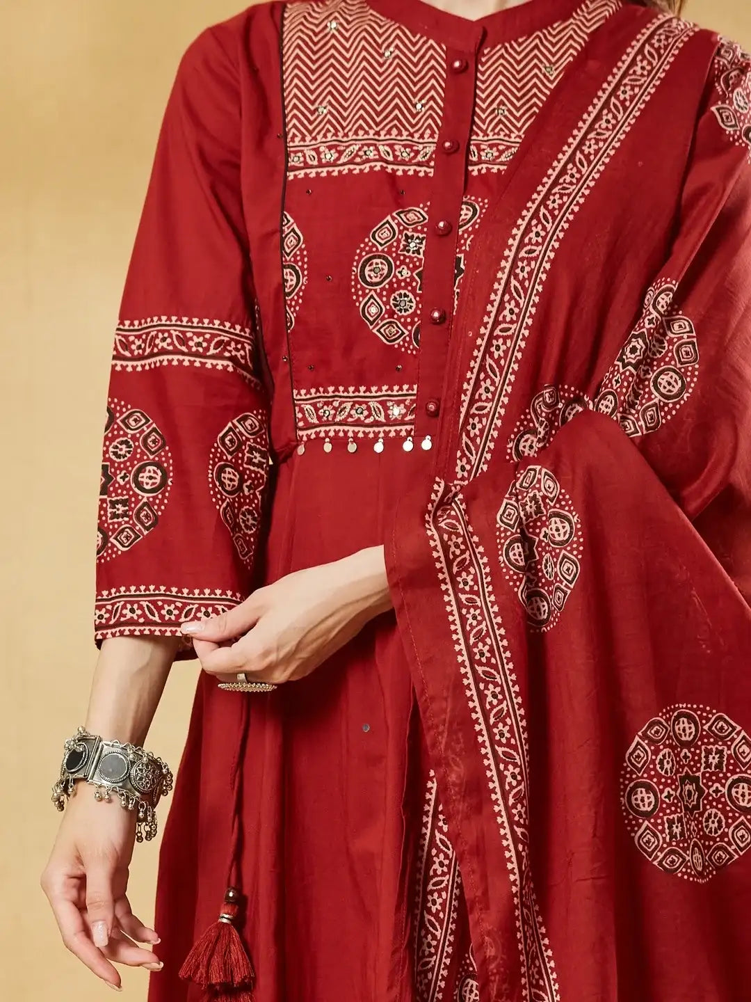 Woman wearing a red Indian ethnic dress with traditional prints and oxidized silver jewelry.