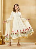 Woman wearing an elegant off-white Anarkali suit with red floral embroidery and gold border.
