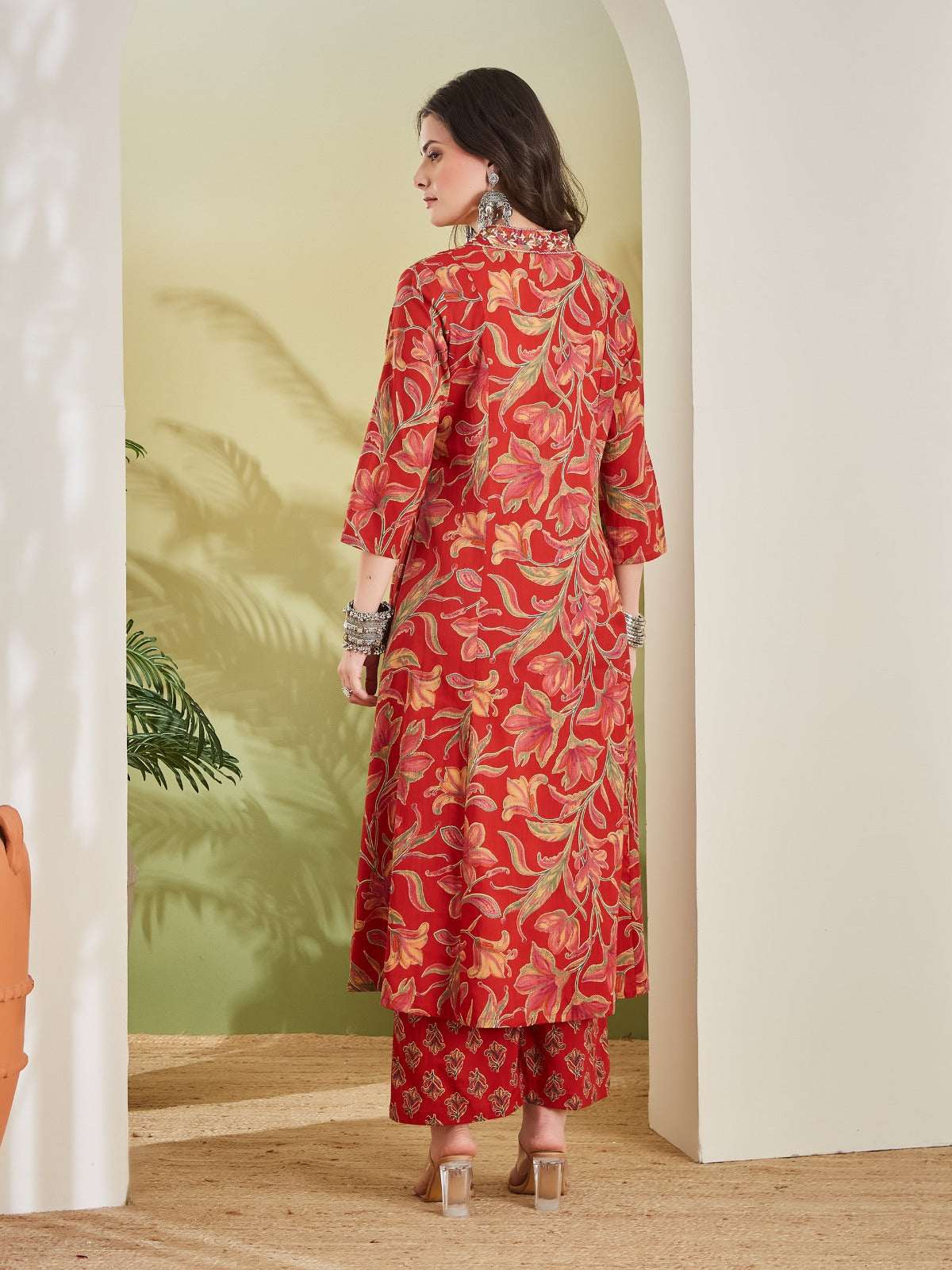 Woman in red floral print Indian ethnic kurta set with matching palazzo pants.
