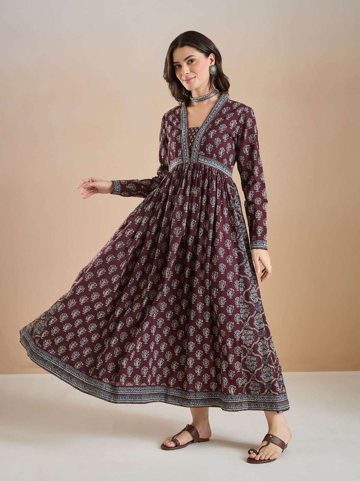 Woman wearing a maroon floral print long ethnic maxi dress with long sleeves.