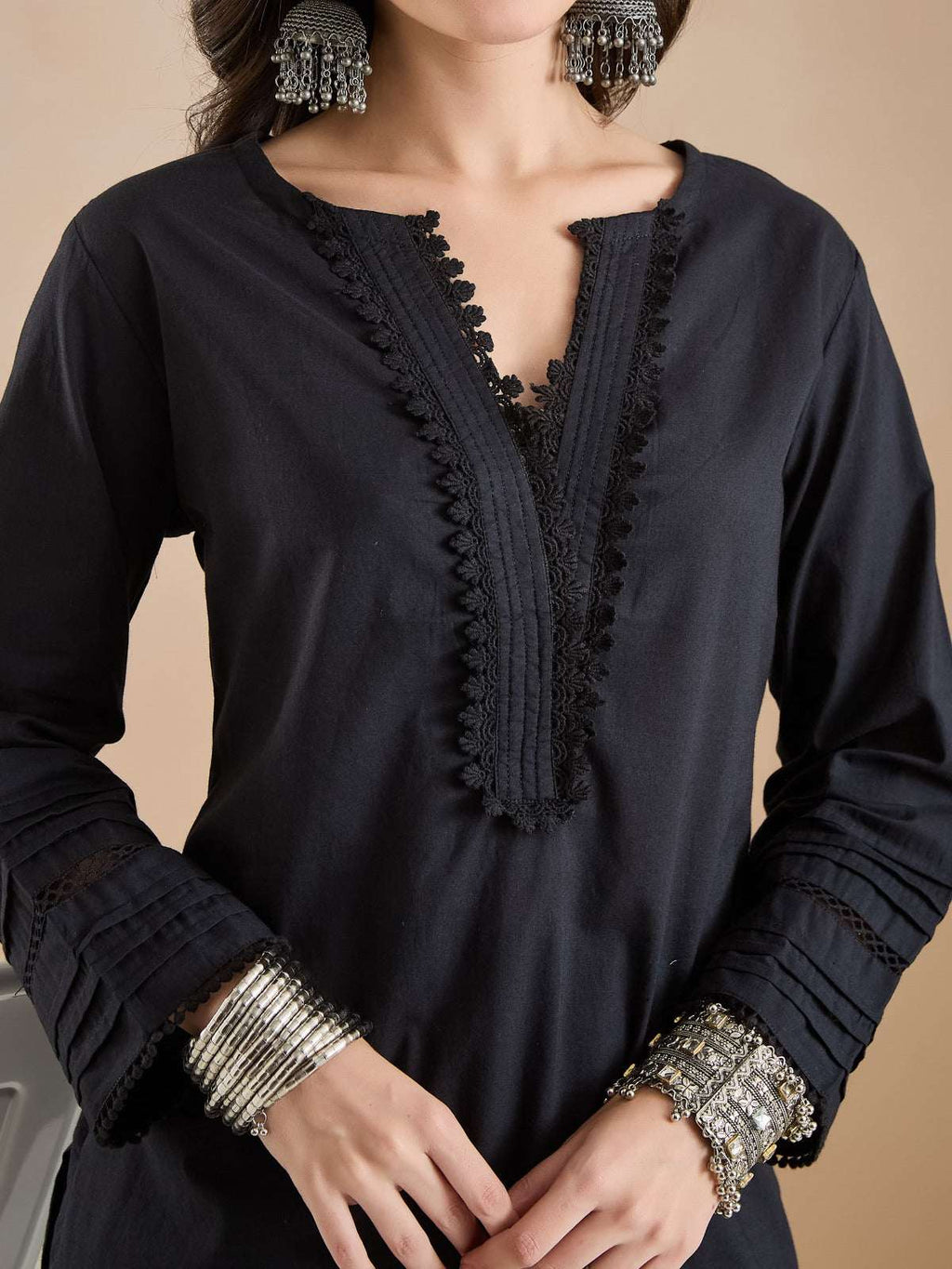 Black ethnic kurta with intricate lace embroidery and long sleeves for women.