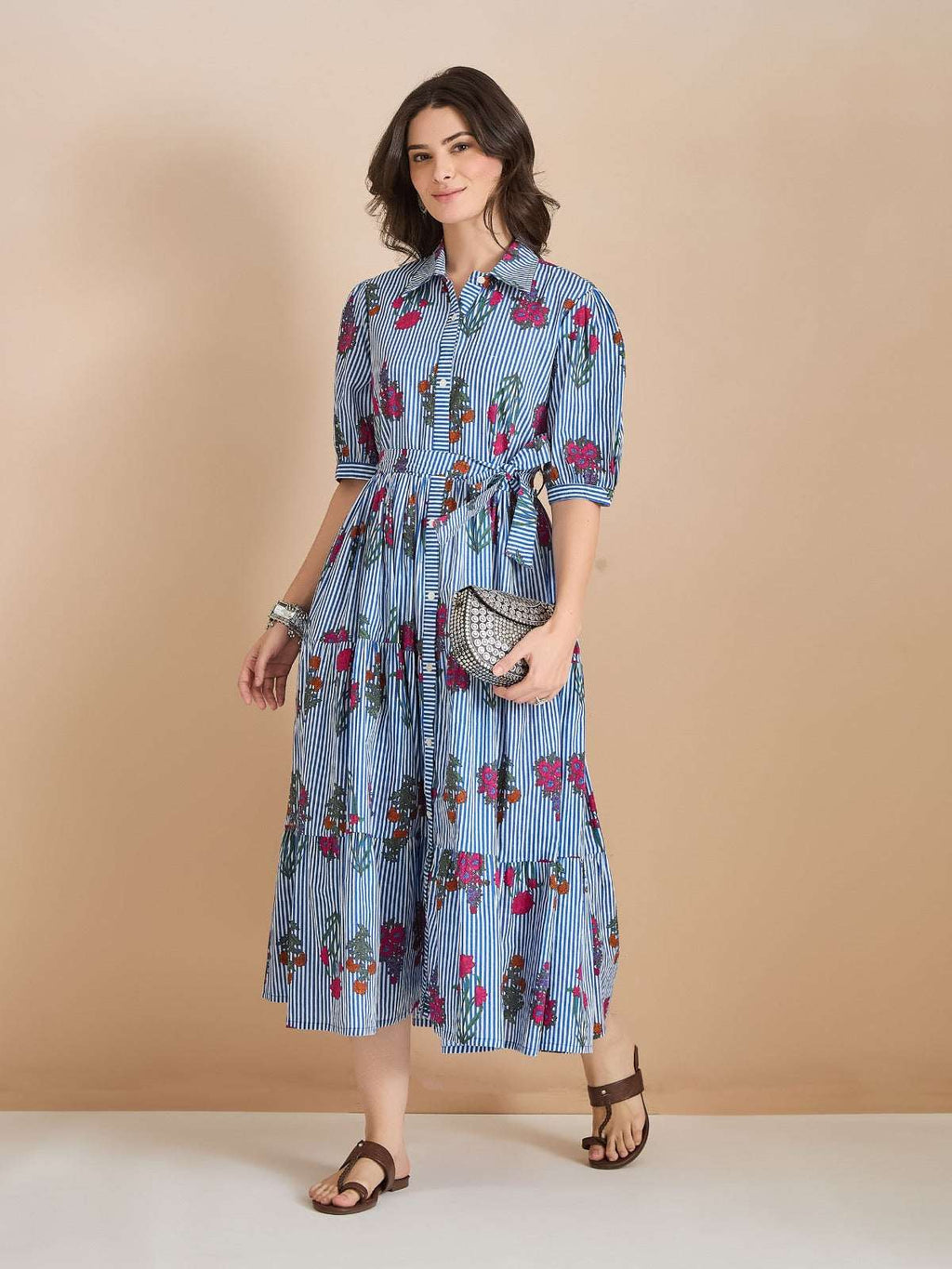 Woman wearing a blue and white striped floral midi shirt dress with a waist tie.
