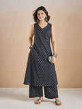 Woman wearing a navy blue printed sleeveless kurta and palazzo set with silver jewelry.