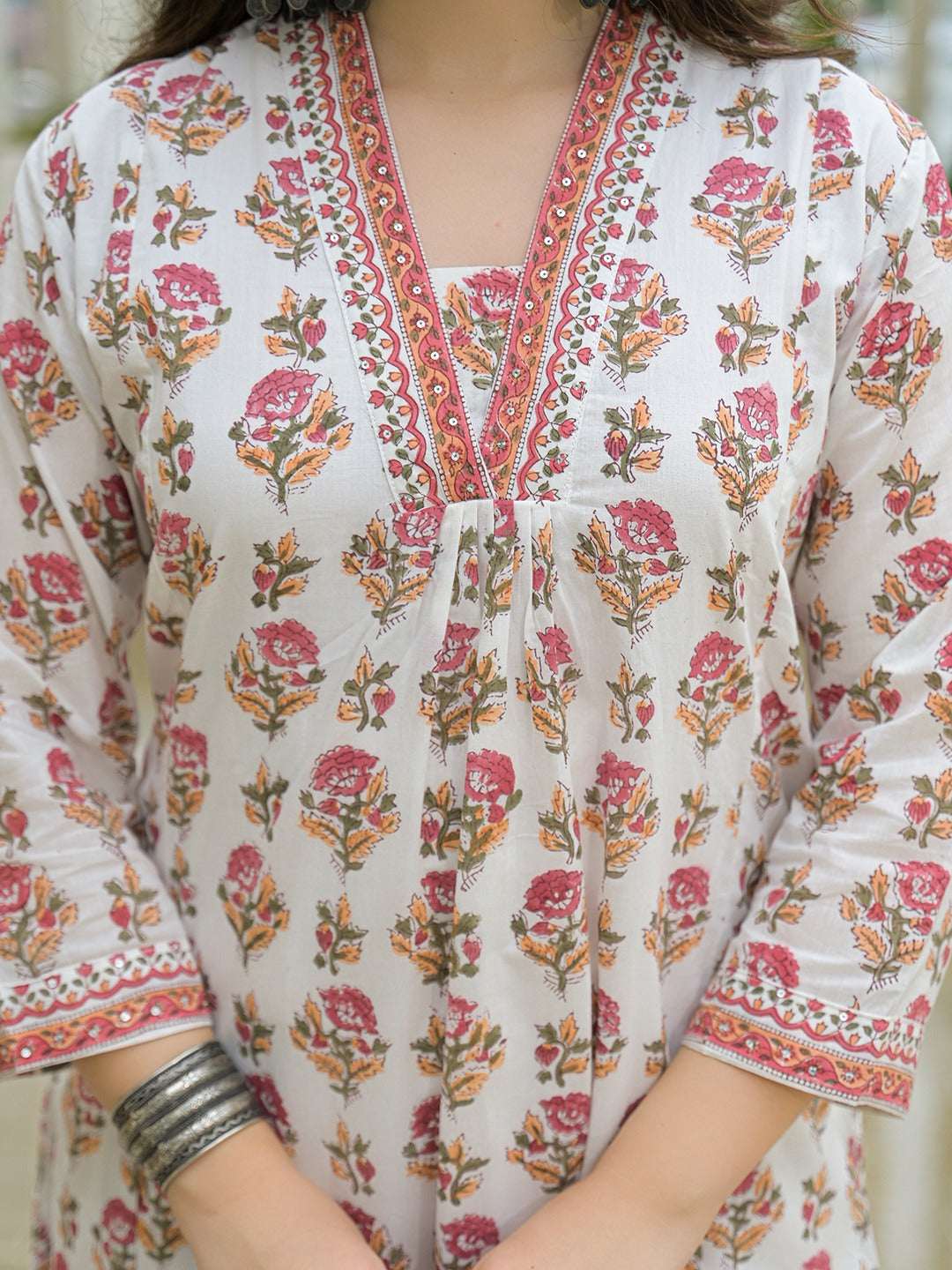 Woman wearing a white floral print cotton ethnic kurta with red border detailing
