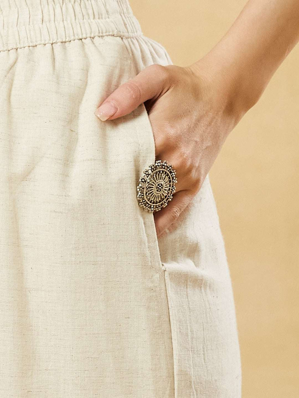 Boho-style statement ring on hand in linen pocket, ethnic jewelry detail