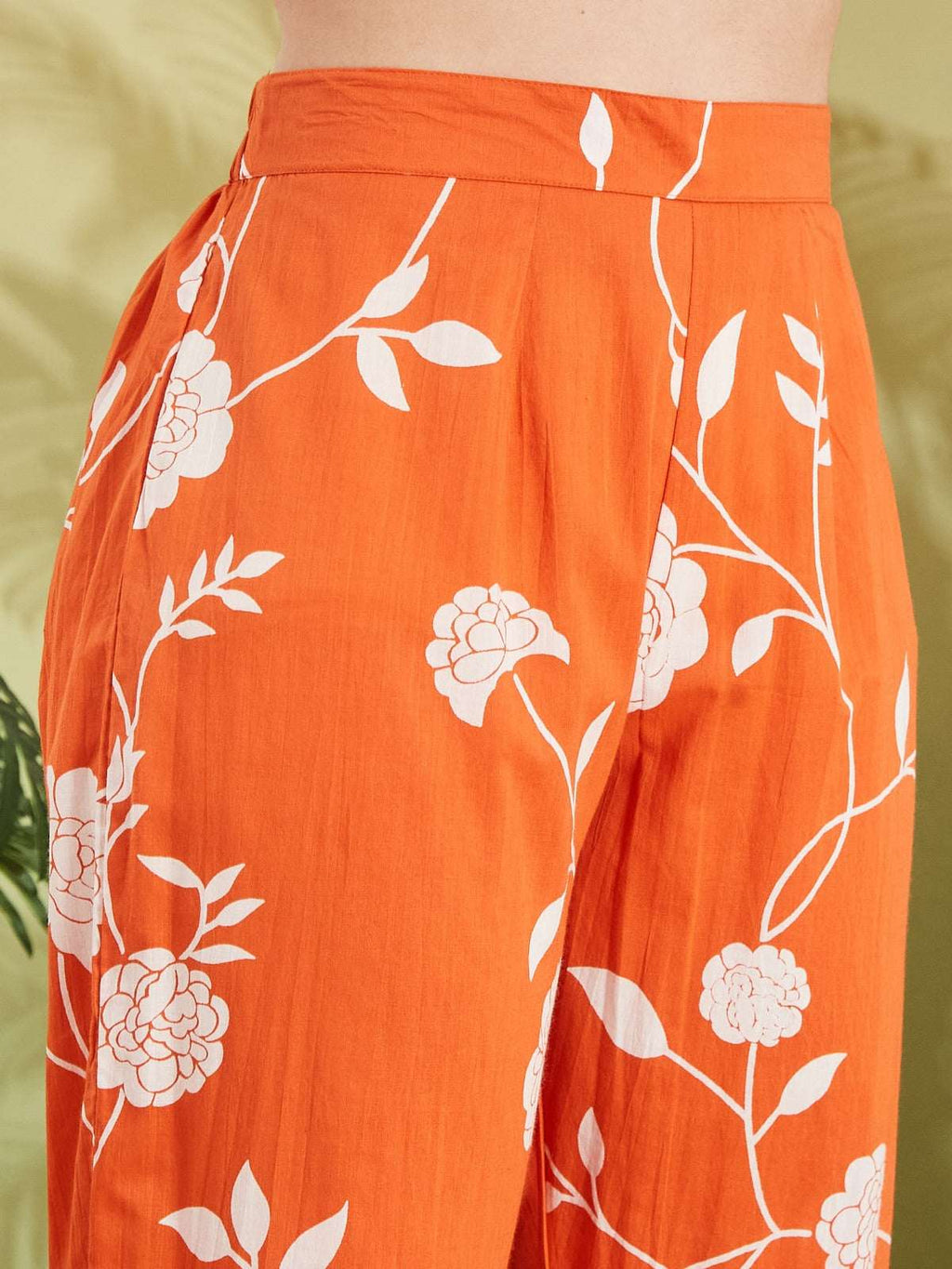 Orange floral print ethnic palazzo pants with white botanical patterns.