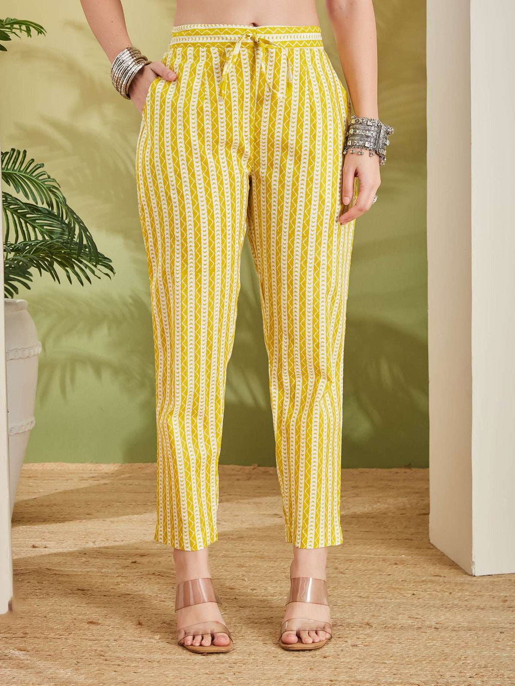 Woman wearing yellow and white patterned ethnic print trousers with drawstring waist.
