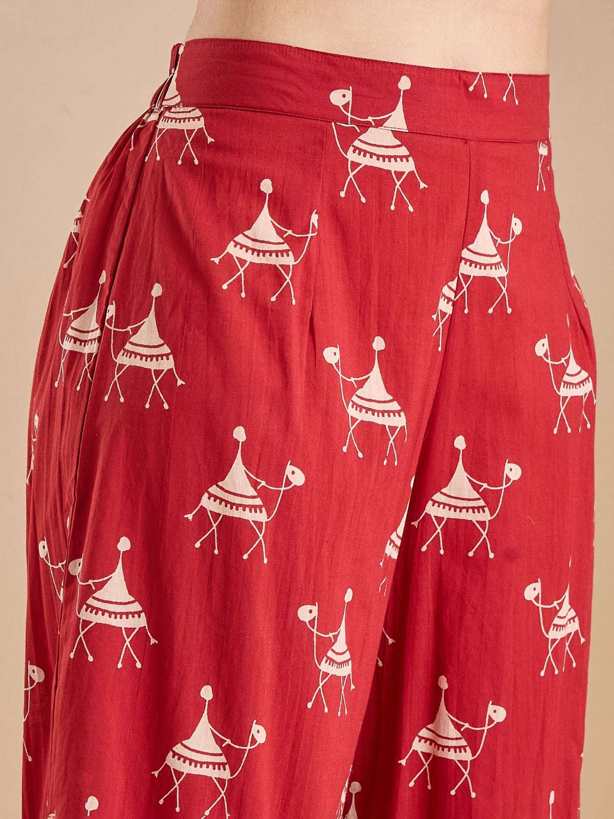 Red ethnic print palazzo pants with white traditional Indian folk motifs.
