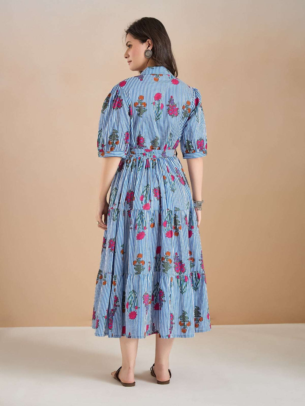 Woman in blue and white striped floral midi dress with puff sleeves