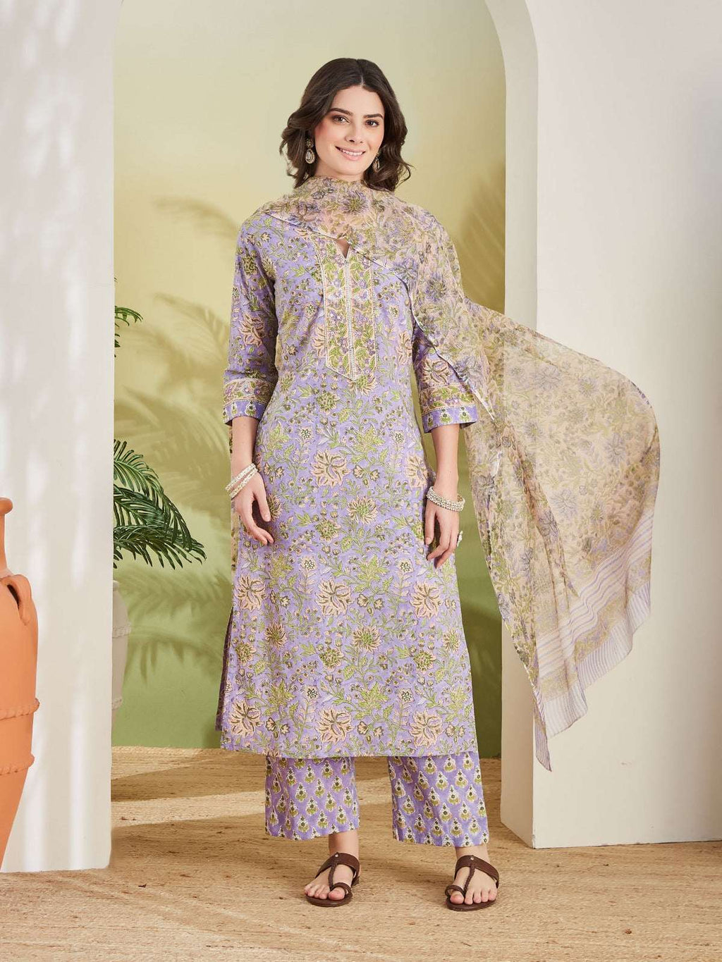 Woman wearing a lavender floral print Indian ethnic salwar kameez with dupatta.