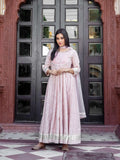 Woman wearing a light pink patterned Anarkali suit with silver embroidery and dupatta.