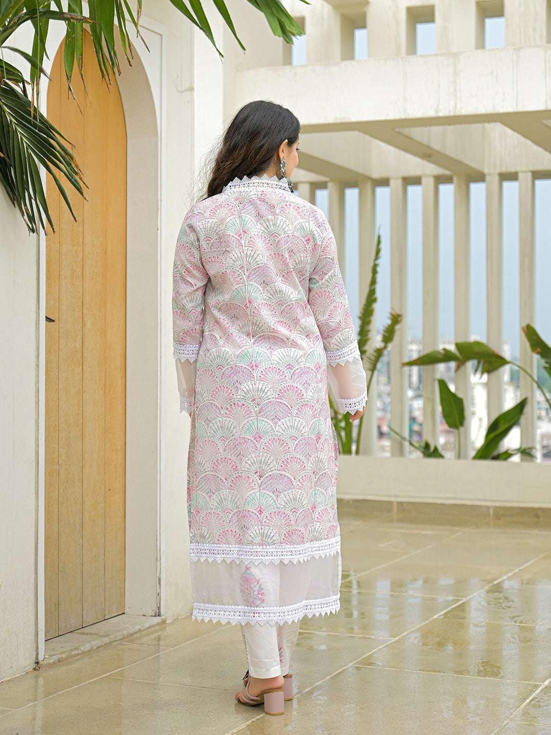 Woman wearing a pink and white printed ethnic long kurta with lace detailing.