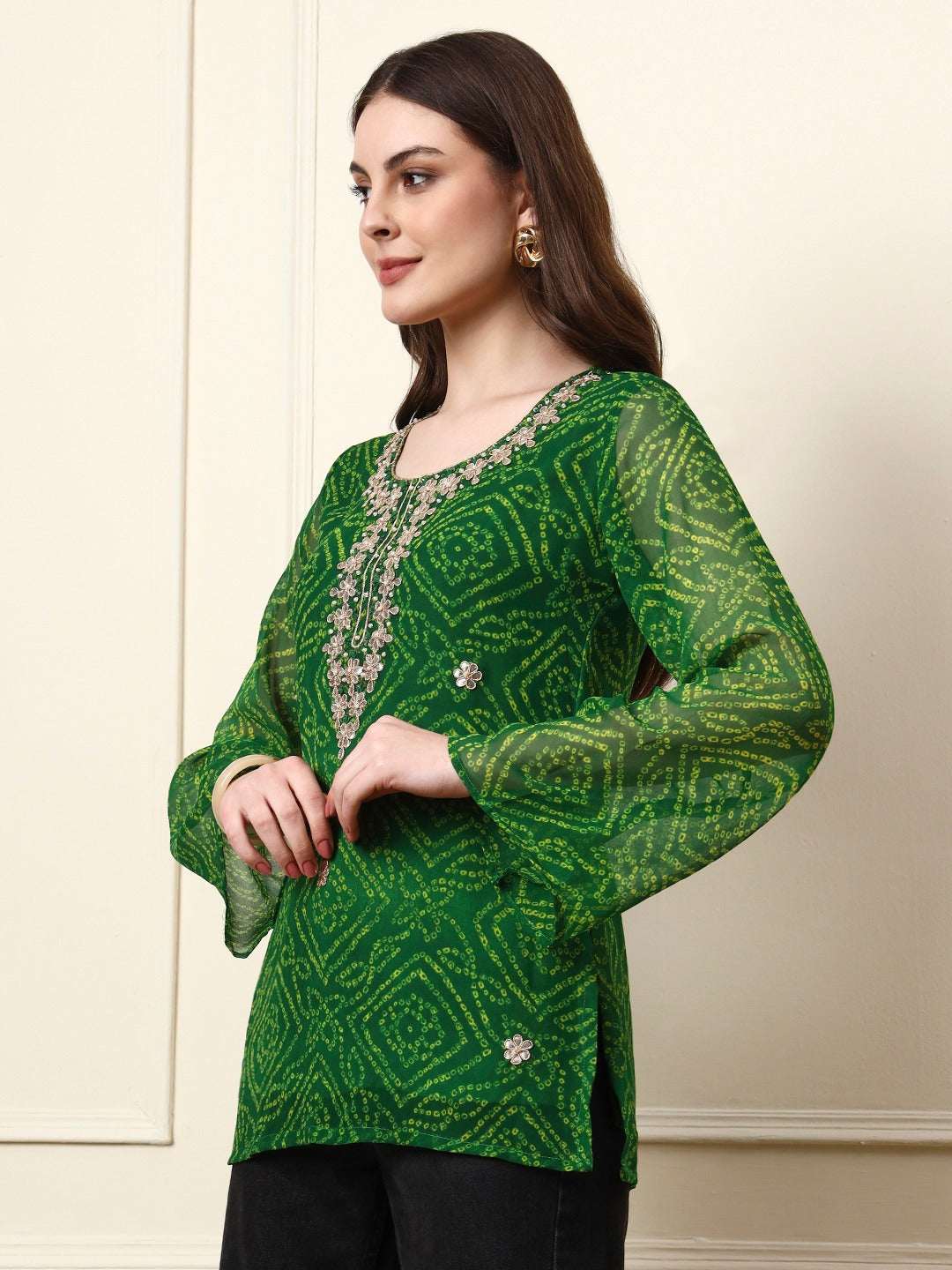 Woman wearing a green bandhani print ethnic tunic with silver embroidery.