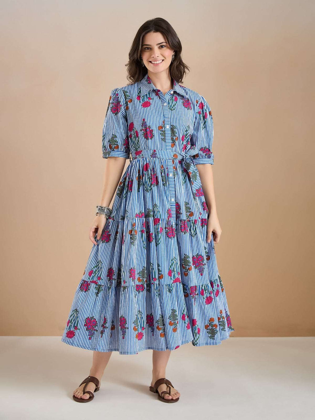 Woman wearing a blue and white striped floral midi dress with short sleeves.