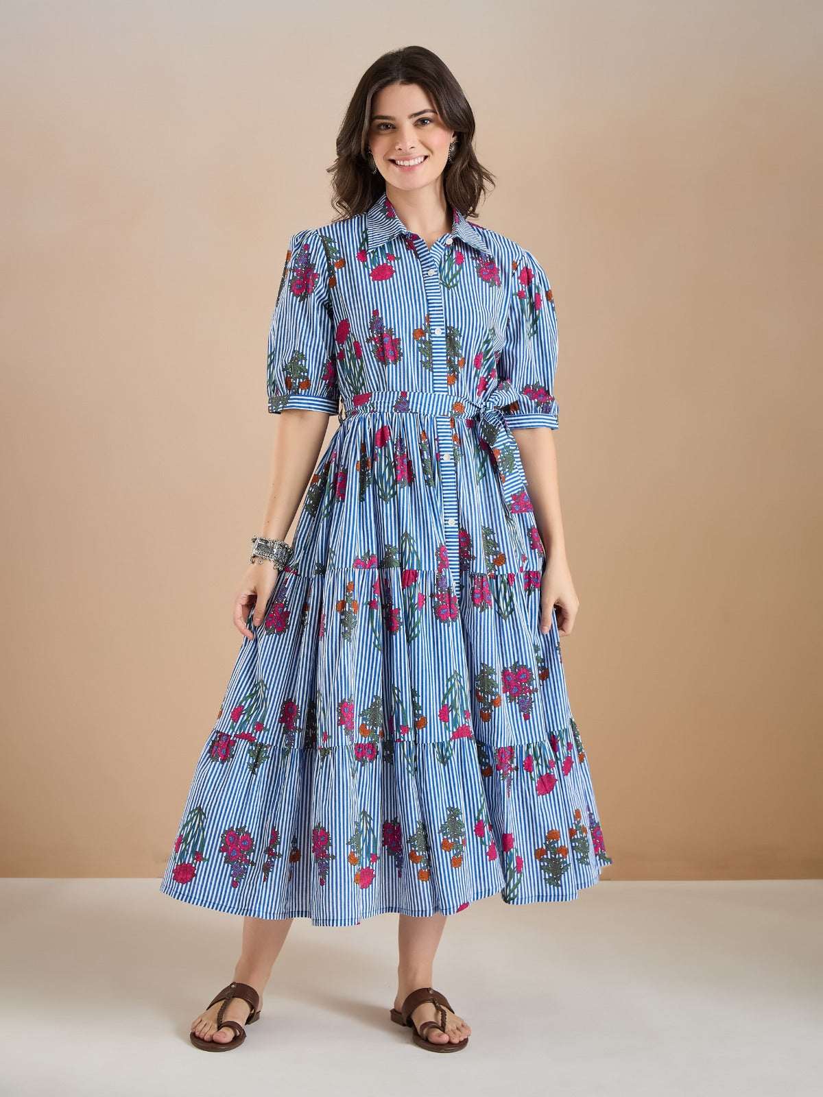Woman wearing a blue and white striped floral midi dress with short sleeves.