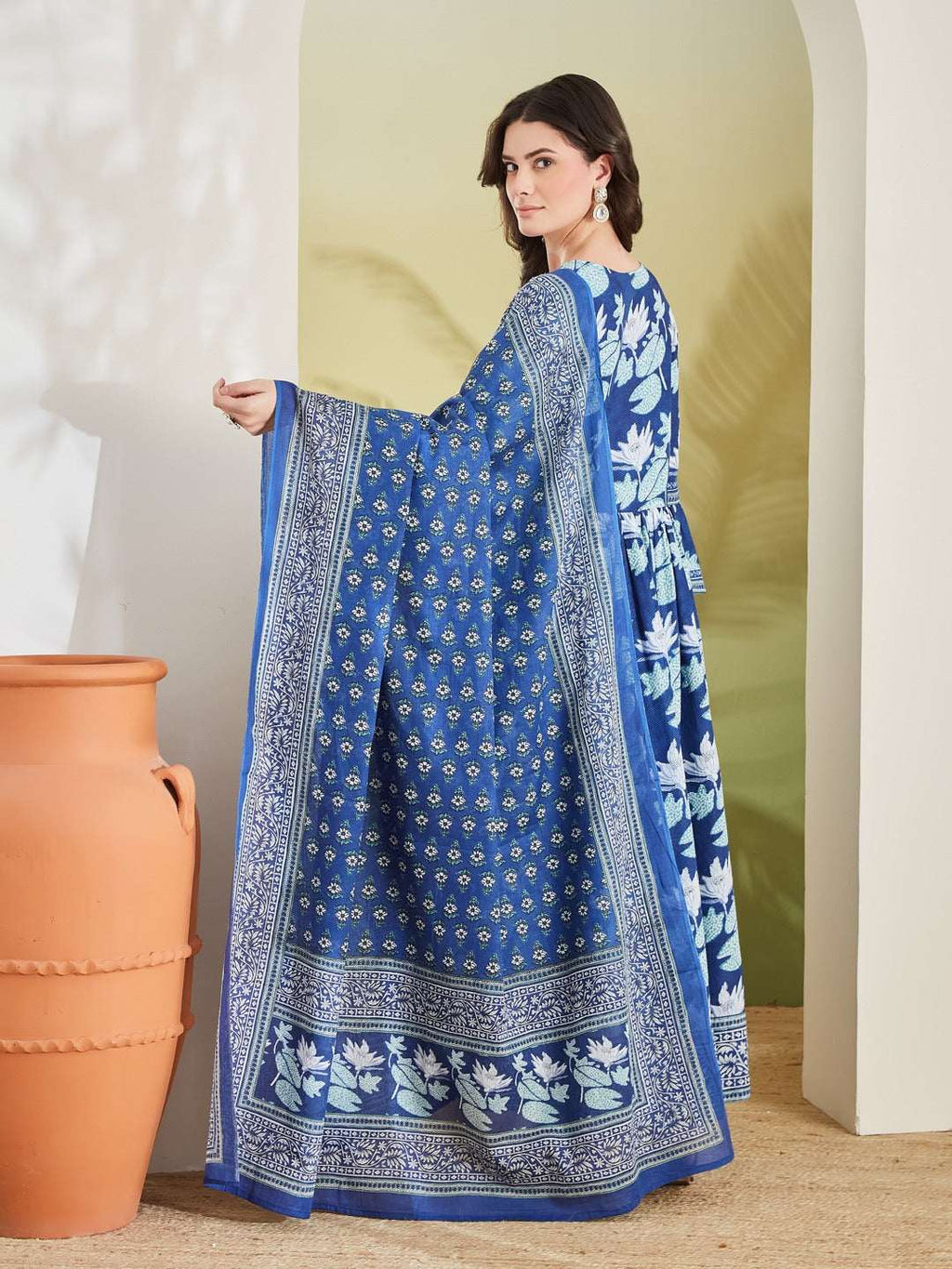 Woman wearing a blue floral print Indian ethnic dress with a matching patterned dupatta.