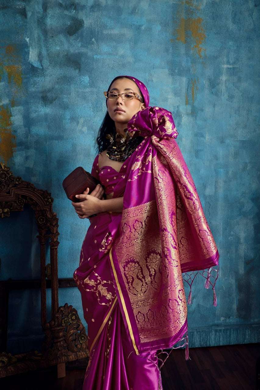 Woman in elegant magenta silk Banarasi saree with gold zari work and traditional jewelry.
