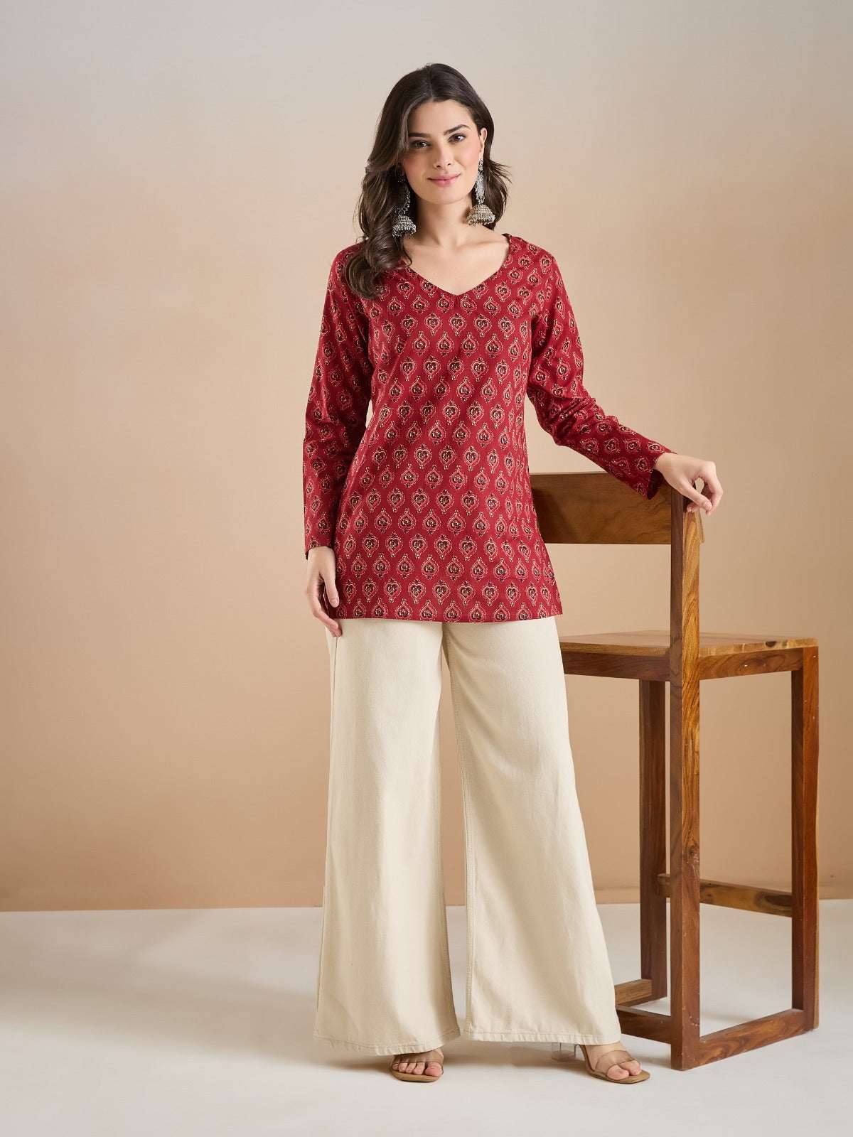 Woman wearing a red printed ethnic tunic with cream wide-leg palazzo pants.