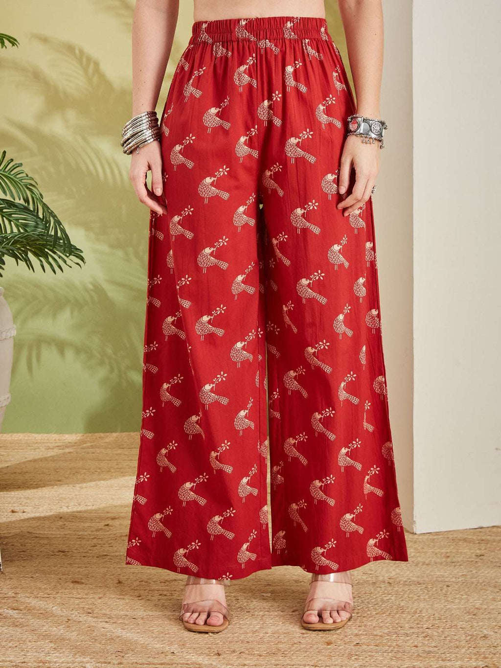 Red silk wide-leg palazzo pants with gold ethnic bird print