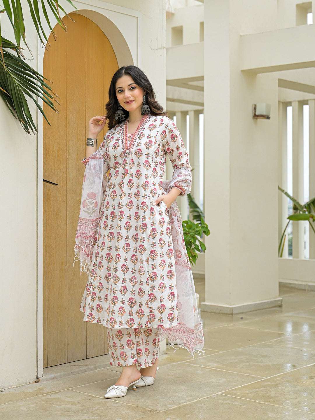 Woman wearing a white floral print cotton kurta set with dupatta and palazzo pants.