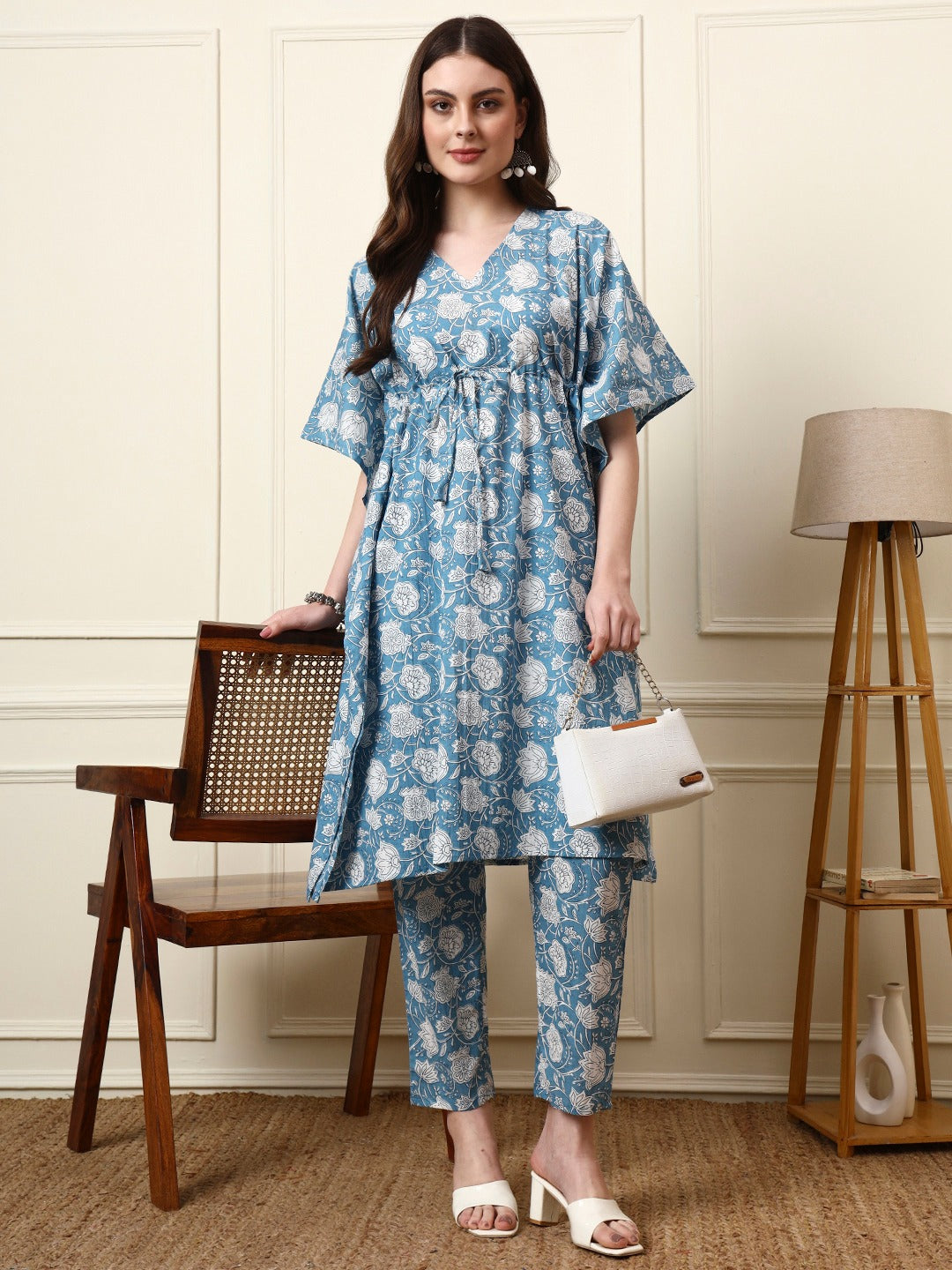 Woman wearing a blue floral print ethnic co-ord set with a kaftan top and matching pants.