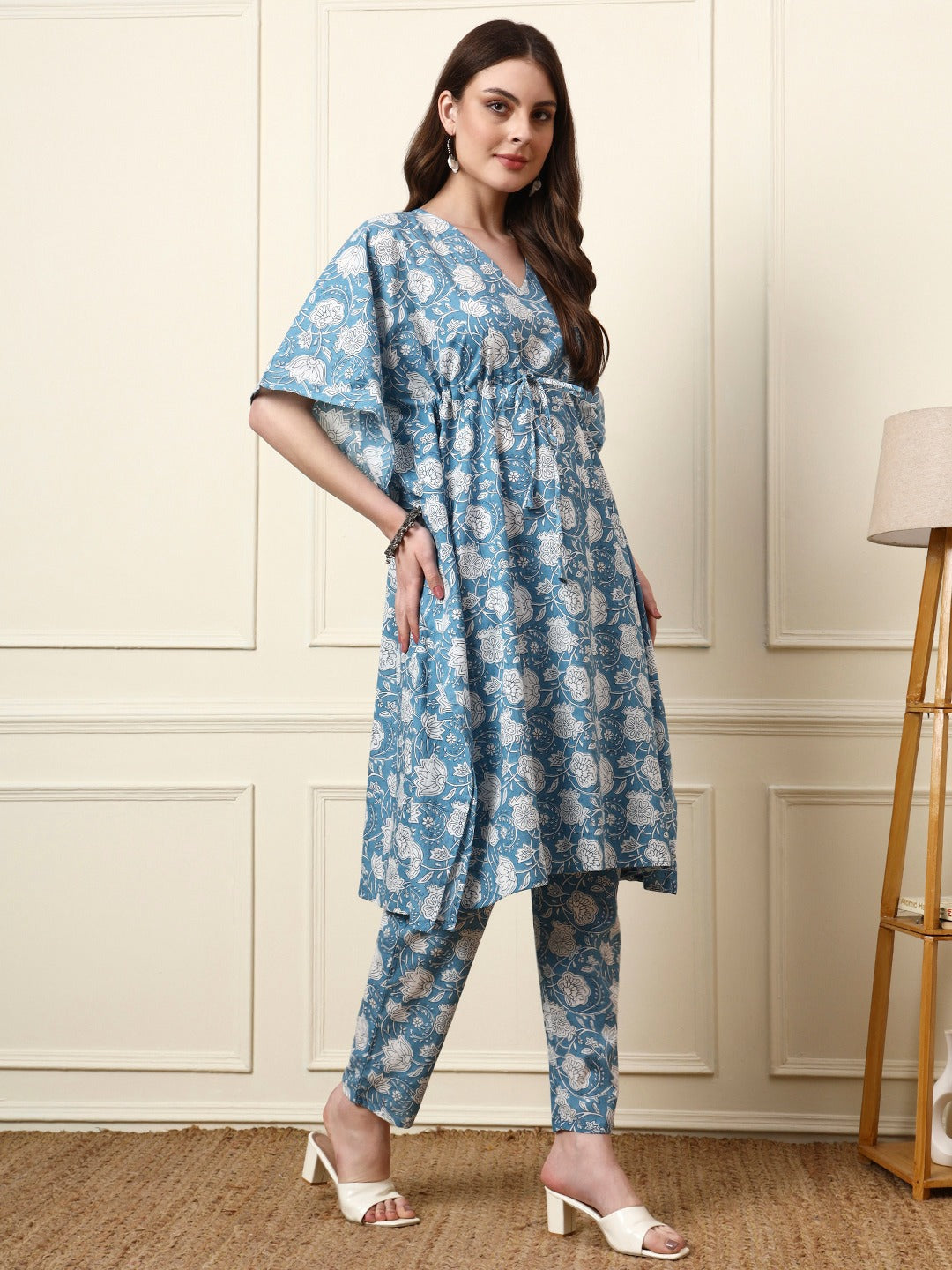 Woman wearing a blue and white floral print Indian ethnic co-ord set with a tunic and pants.