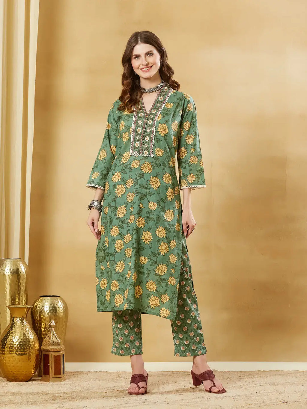 Woman wearing a green floral print Indian ethnic kurta and matching trousers set.