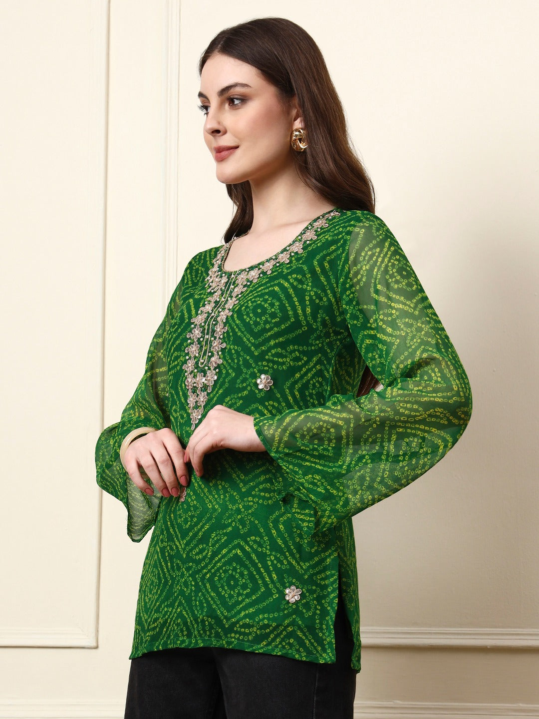 Woman wearing a green bandhani print ethnic tunic with silver embroidery.