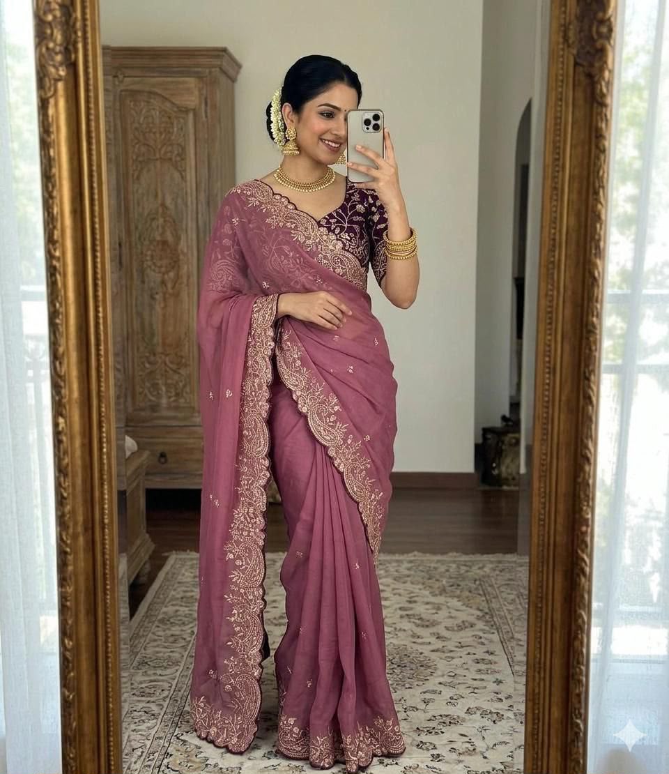 Woman wearing a mauve embroidered saree with a gold-accented blouse and traditional jewelry