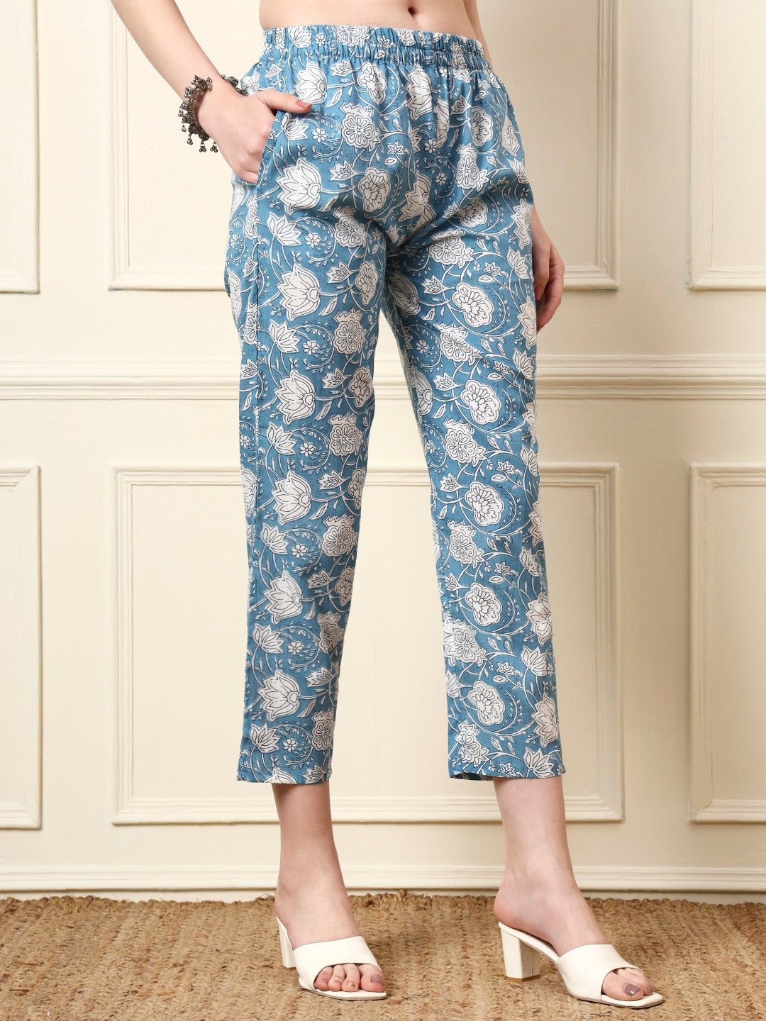 Woman wearing blue floral print ethnic cotton trousers with an elasticated waist.
