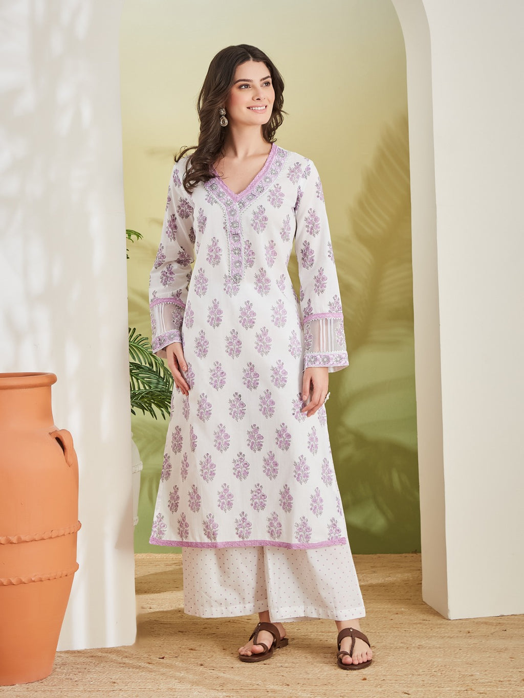 White kurta with purple floral print, V-neck, and lace trim, paired with polka dot palazzo pants